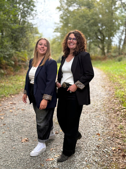 Blazer noir avec détail léopard porté sur un chemin en automne - Abana Boutique 64480