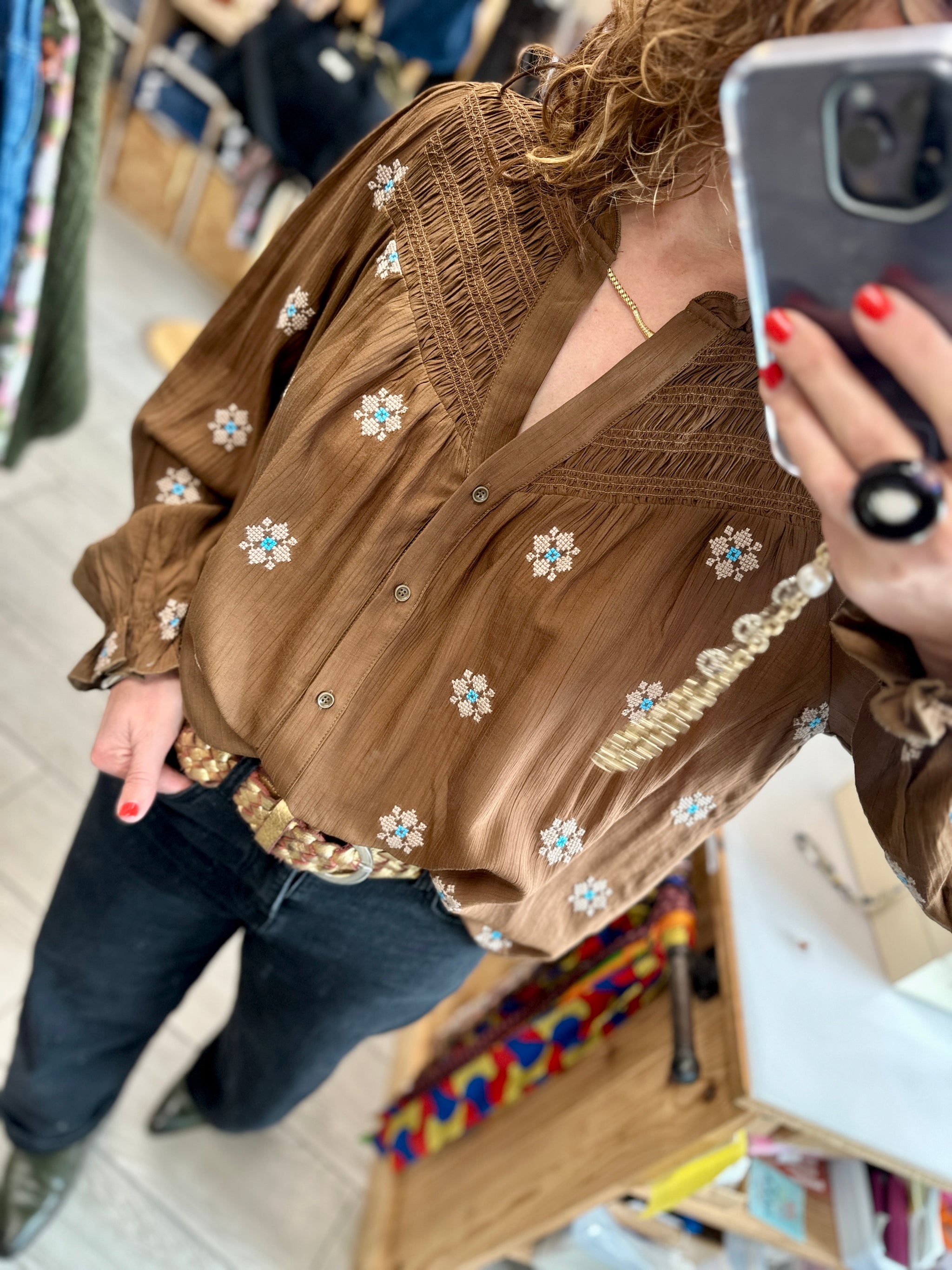 Détail du col V et des smocks sur une blouse fluide à motifs brodés - Abana 64250