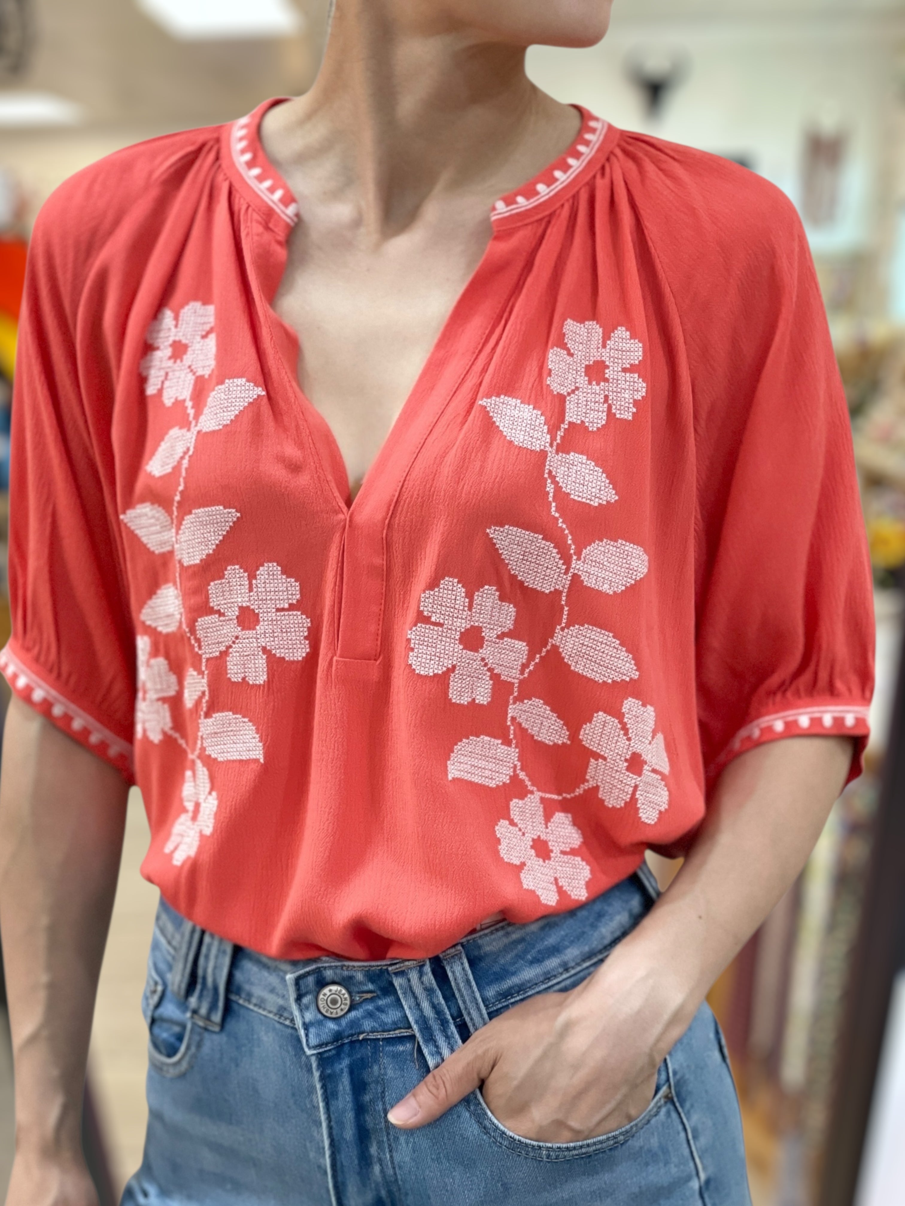 Look d'été féminin avec la blouse corail brodée de la boutique Abana, à Ustaritz dans le Pays basque