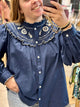 Blouse bleu jean grande taille avec broderies écrues et col volanté, manches longues boutonnées, style bohème chic femme - Abana 64480