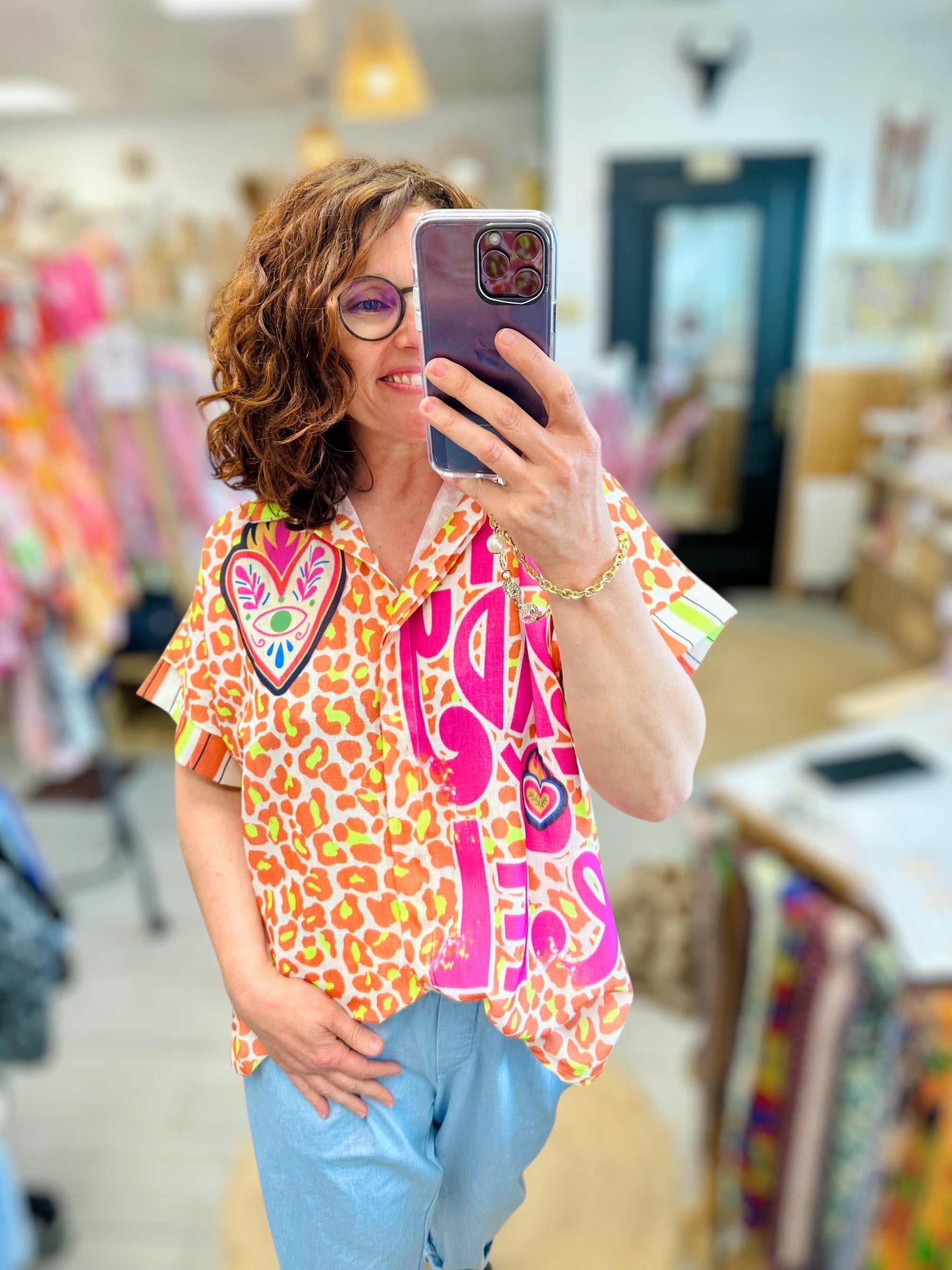 Chemise imprimée léopard rose et orange portée à la boutique Abana, look fun et audacieux pour femme