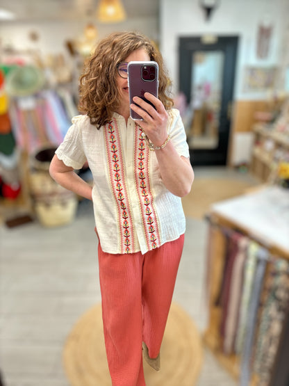 Tenue bohème avec chemise écrue brodée et pantalon fluide corail