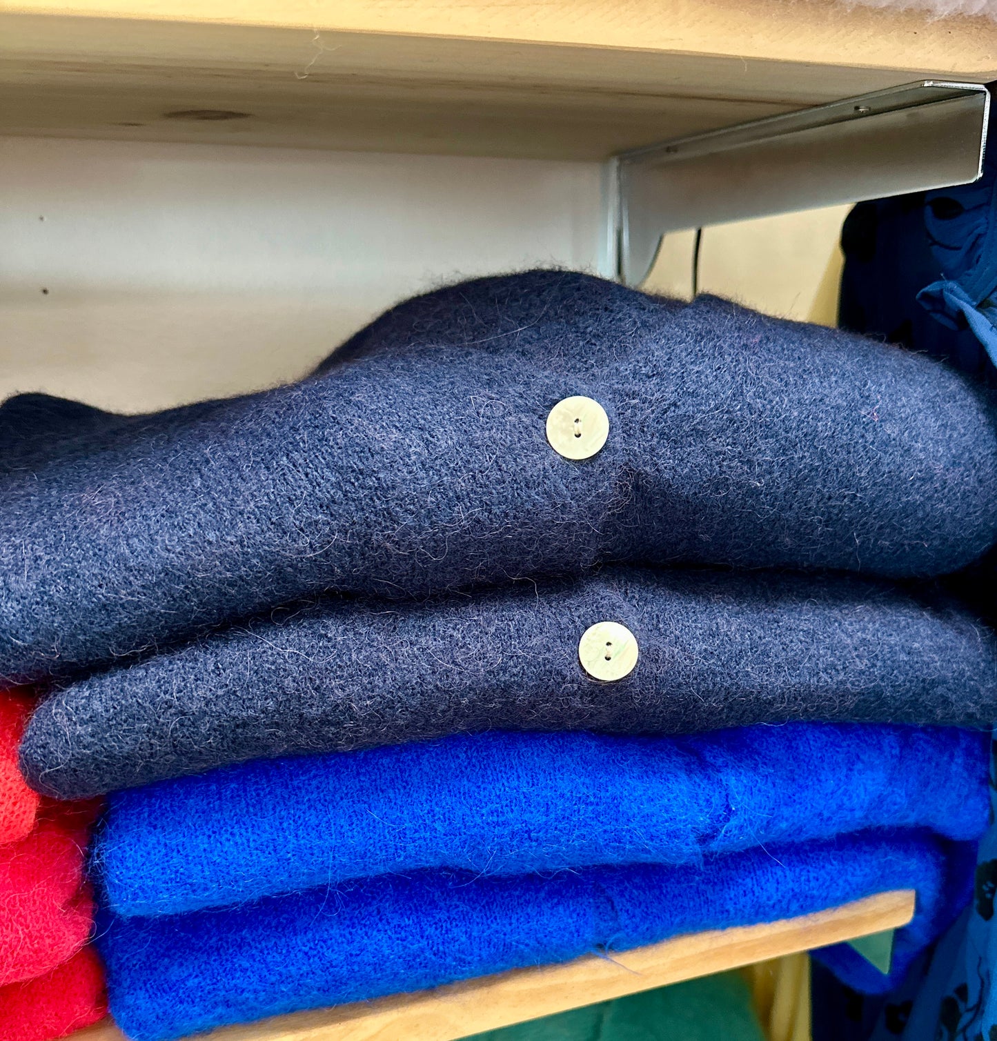 Zoom sur un gilet doux col en V bleu et boutons nacrés - Abana 64990