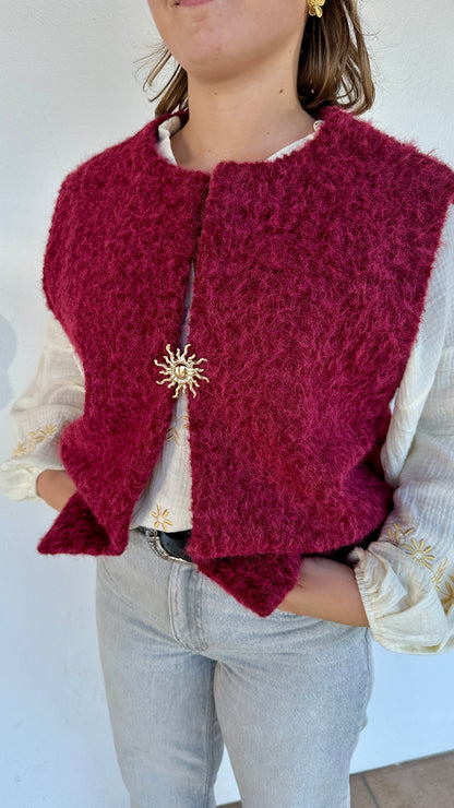 Texte alt 2 : Gilet framboise sans manches en sherpa, détail broche dorée en forme de soleil – Abana Boutique Pays Basque