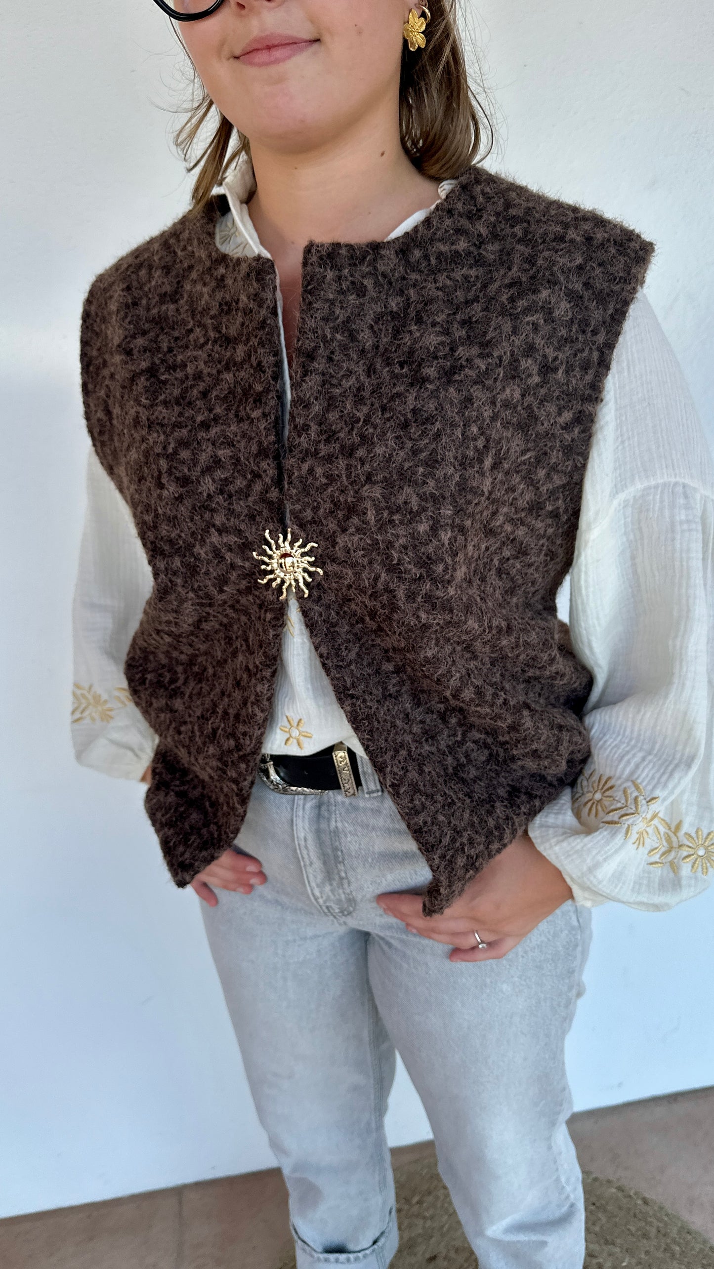 Texte alt 4 : Gilet chocolat sans manches en matière sherpa, gros plan sur la broche soleil– Abana Ustaritz 64990