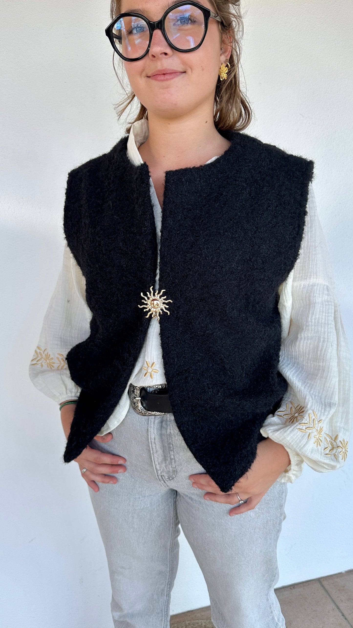 Gilet noir sherpa sans manches, fermeture broche soleil dorée, tenue confortable et élégante – Abana Boutique Ustaritz 64100