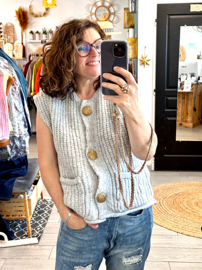 Gilet sans manches Mila, maille épaisse et boutons dorés, parfait pour un style cosy et élégant.