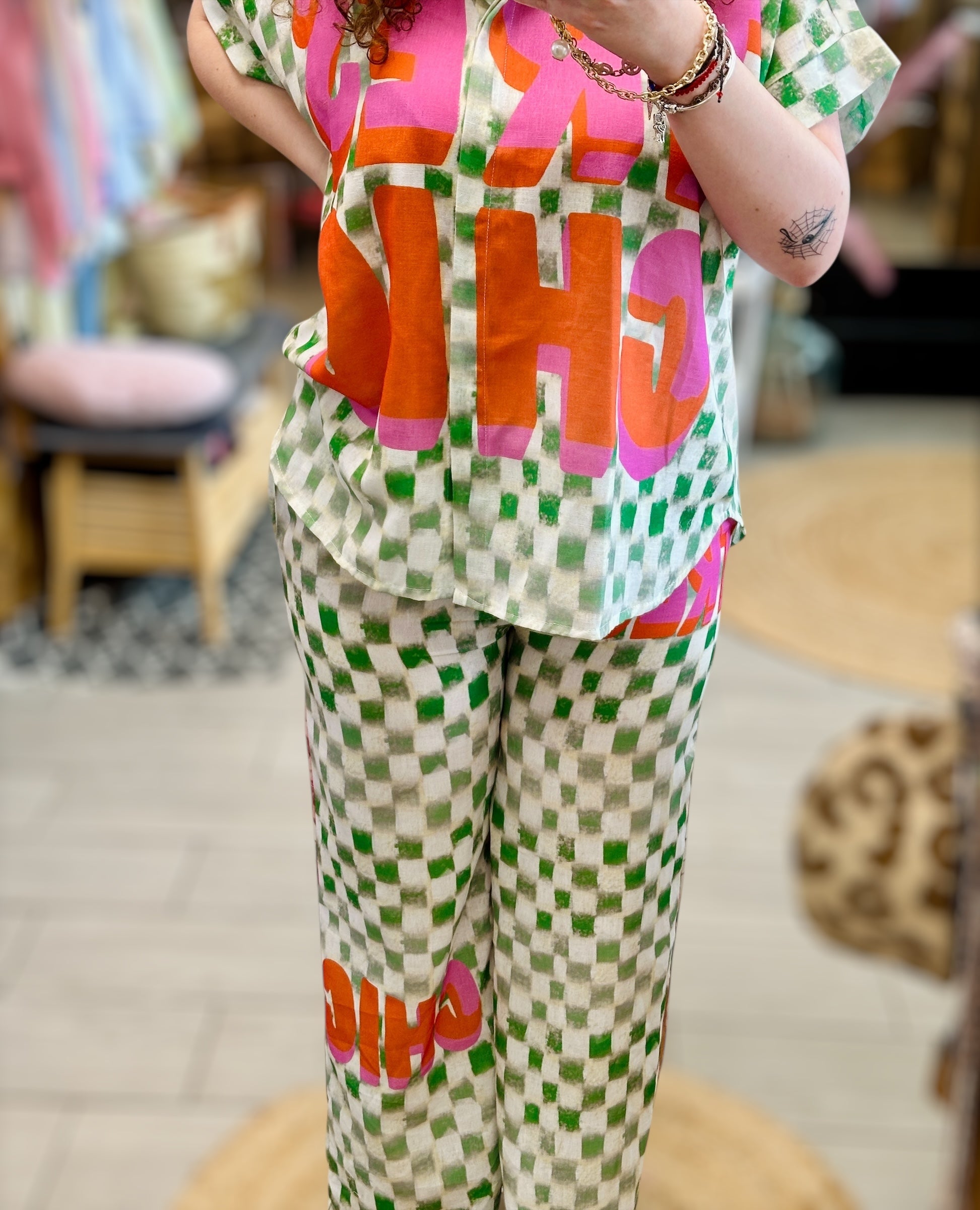 Pantalon Très Chic Abana – motif avant à carreaux vert et message TRÈS CHIC en rose et orange, disponible à Ustaritz