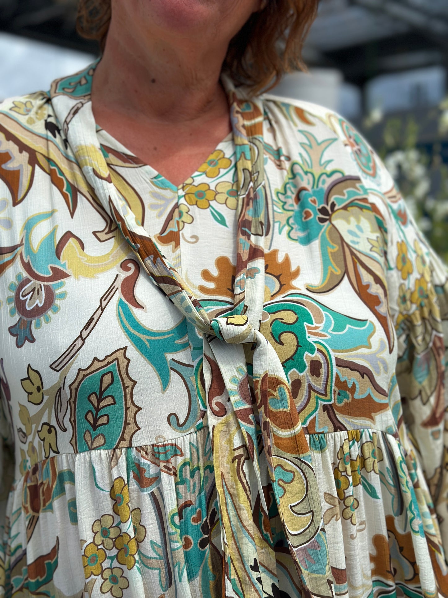 zoom sur le motif vert emeraude et chocolat et le col ruban de la robe ongue grande taille maelle nina carter béziers narbonne carcassonne