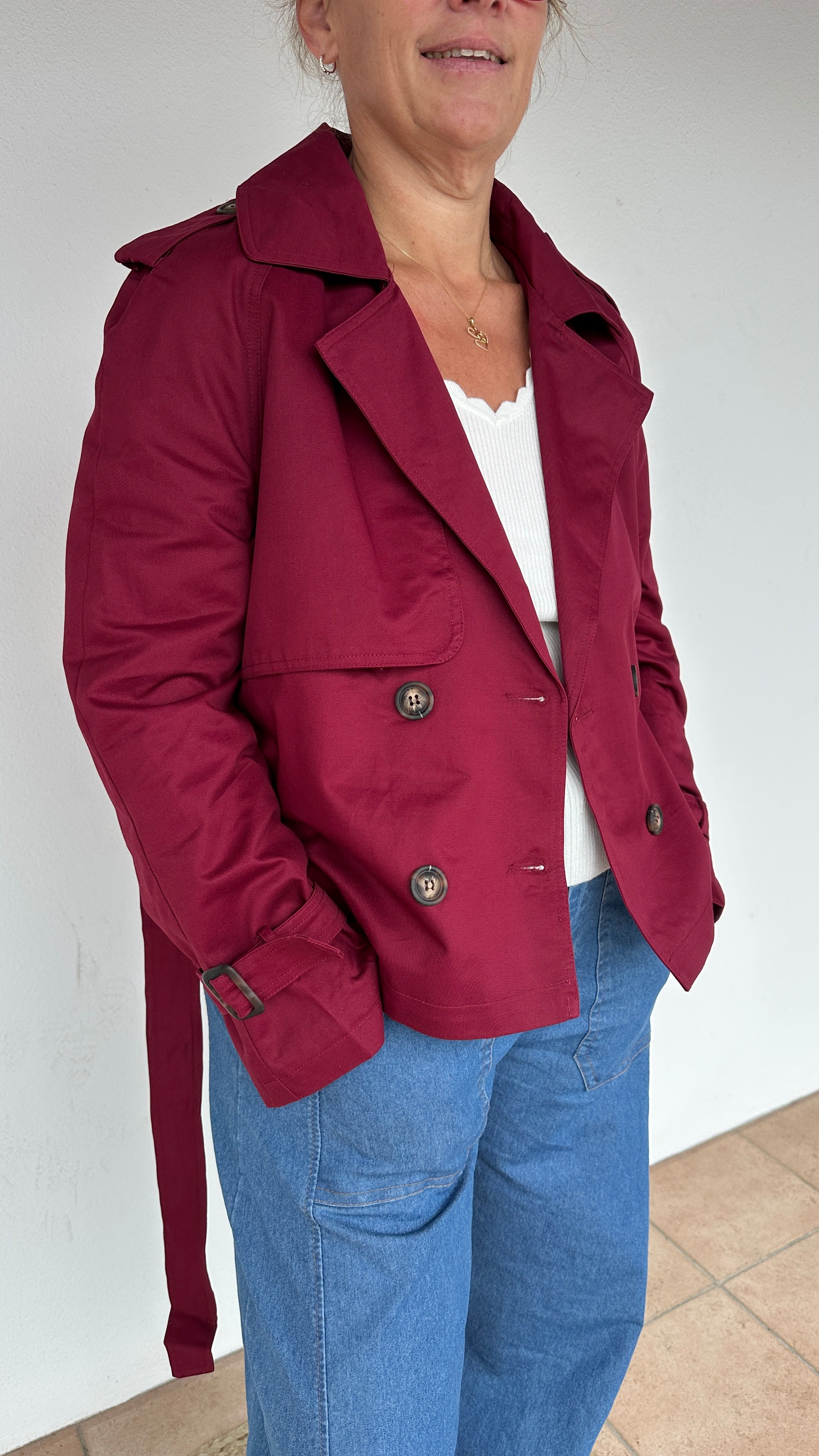 Vue de profil du trench court bordeaux, manches retroussées pour un look casual –  Abana Boutique Ustaritz