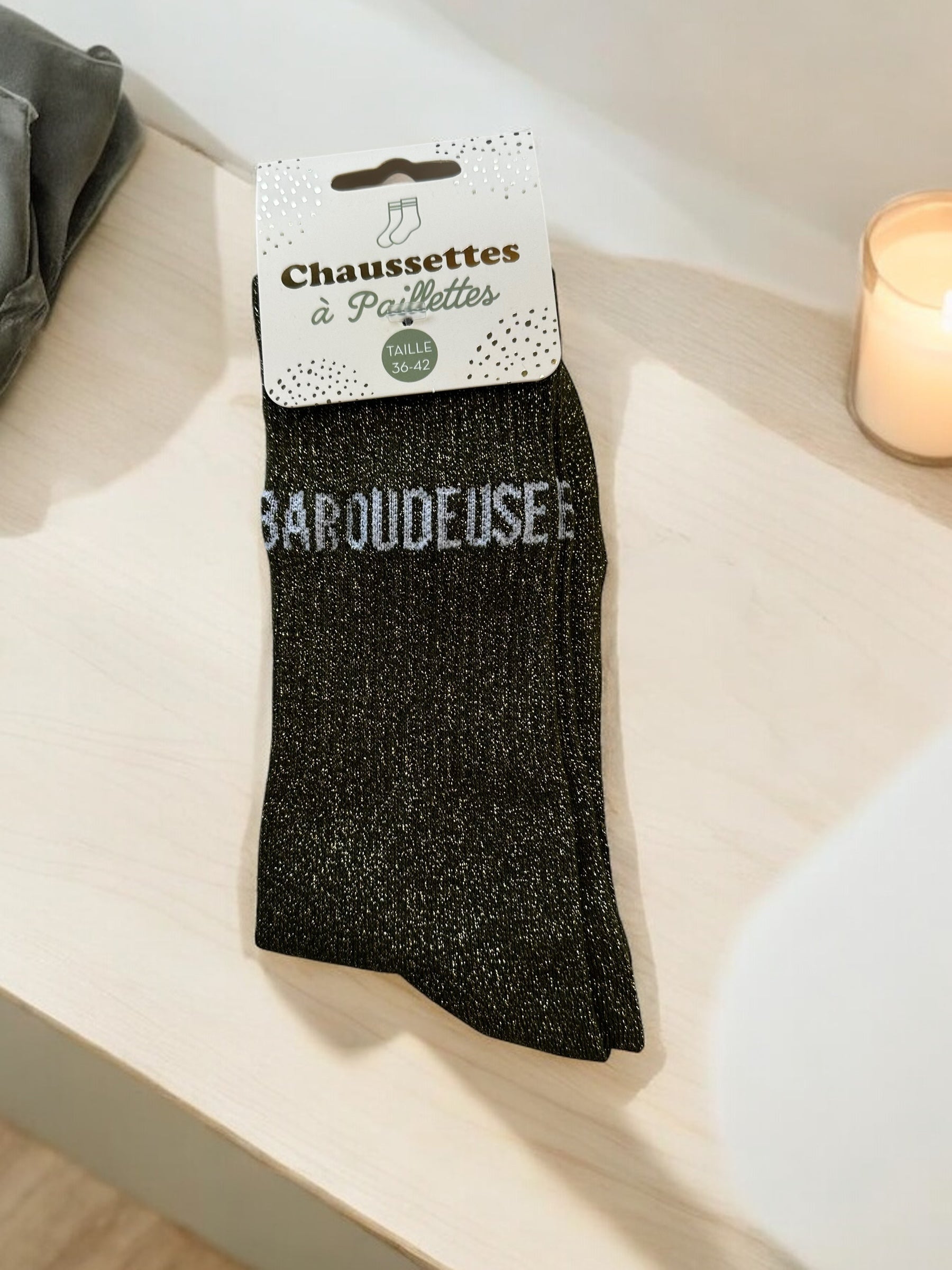 Détail des chaussettes scintillantes baroudeuseavec différents noms en blanc, parfaites pour un look fun et original